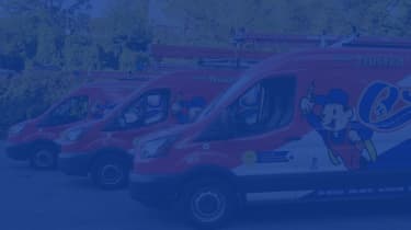 3 red, white and blue electrician service vans parked beside one another